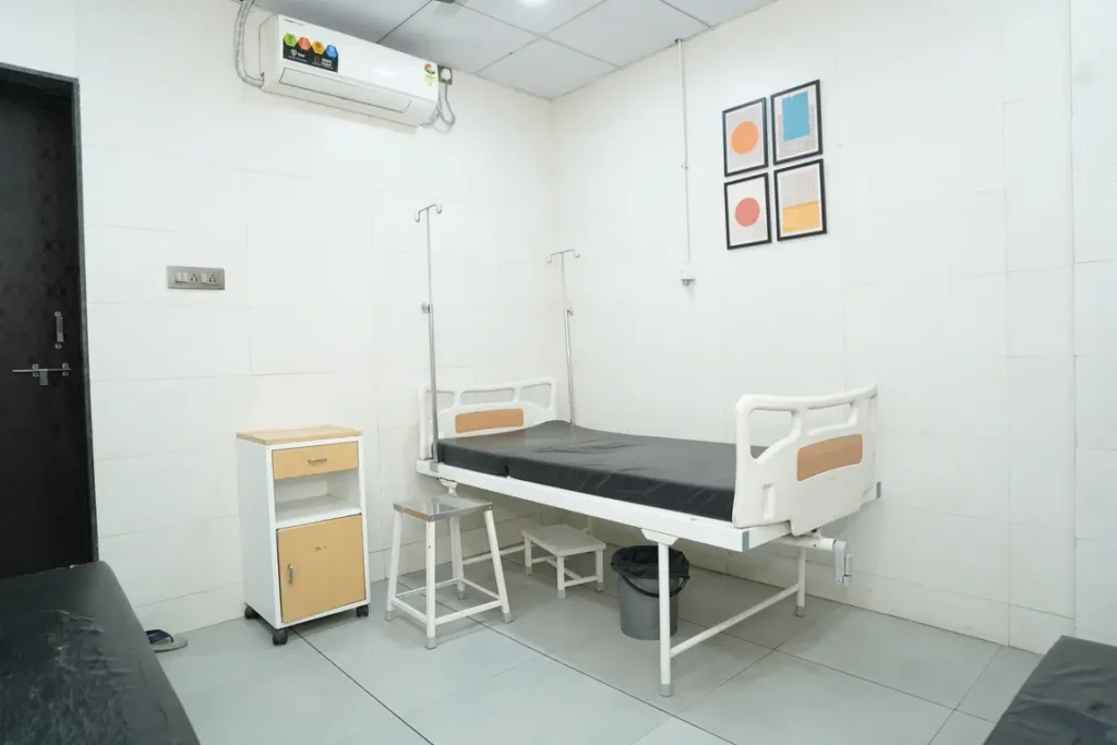 Patient room with bed and monitoring equipment at iSHA Hospital in Vapi, Gujarat